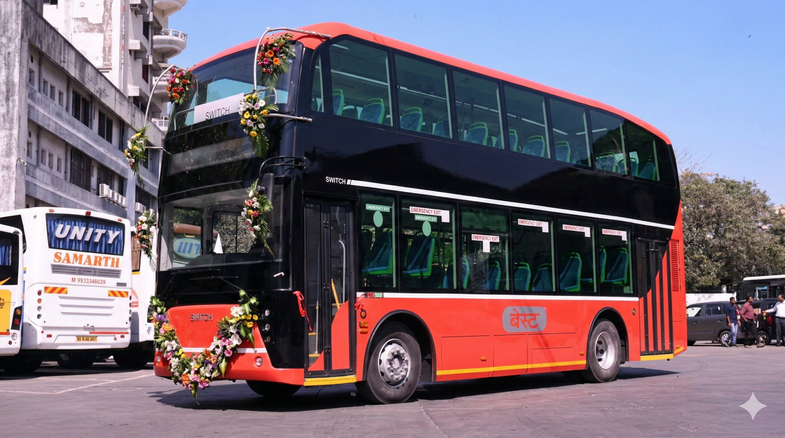 A modern blue and white electric open-top double-decker bus with 'Heritage Tour' written on it, parked in front of Vijay Chowk in Delhi.